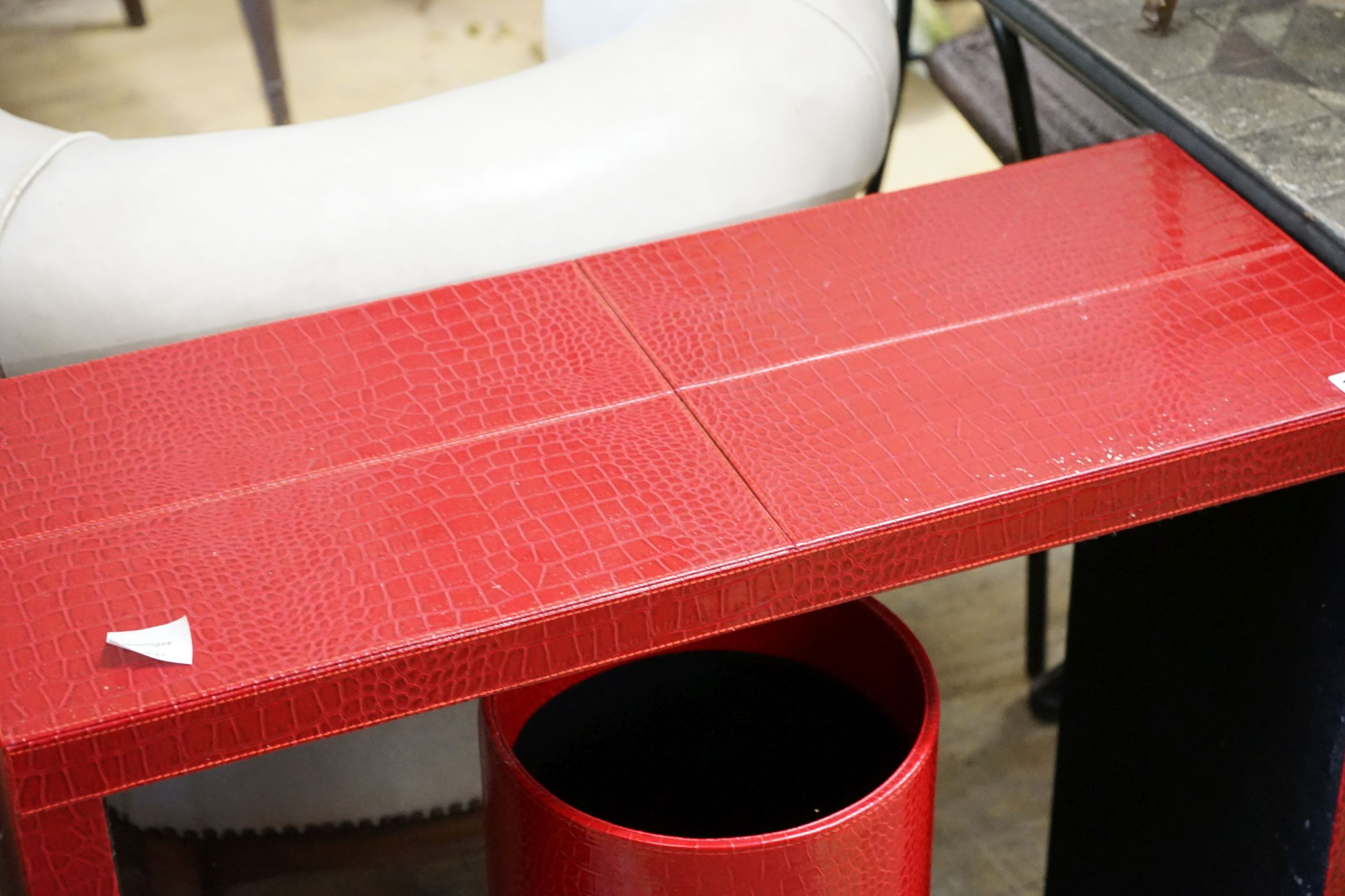 A contemporary red faux crocodile console table, width 80cm, depth 32cm, height 70cm and a stick stand